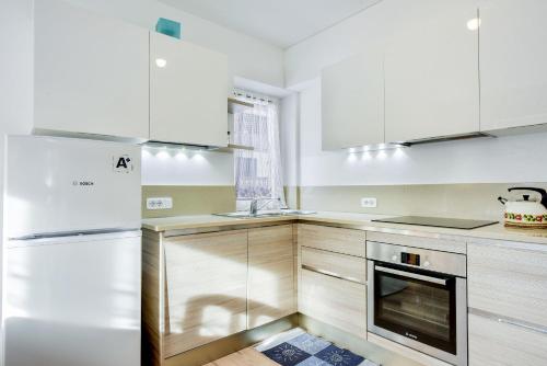 a kitchen with white cabinets and a stove top oven at Ciasa Christina in Moena
