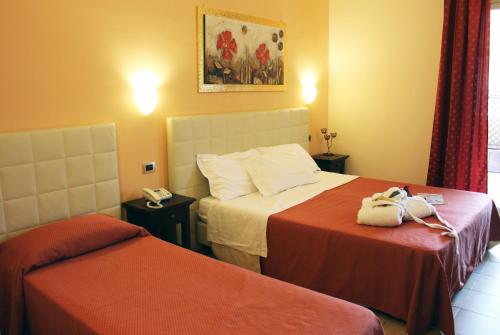 a hotel room with two beds and a phone at Hotel Vittorio Emanuele in Floridia