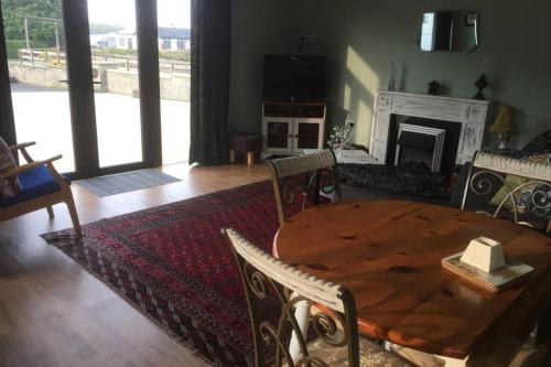 a living room with a wooden table and a fireplace at Cosy rural self catering annex in Magherafelt