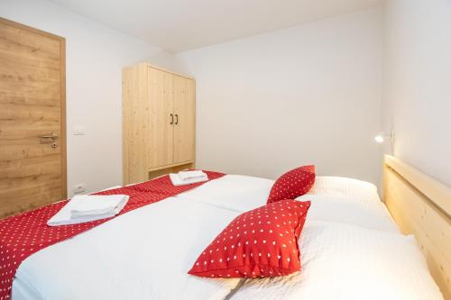 a bedroom with a bed with red and white pillows at Bohinj Apartments Goldhorn Kingdom in Bohinj