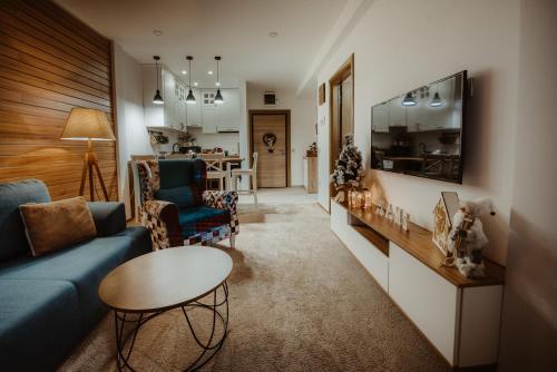 un soggiorno con divano blu e tavolo di WonderWood Family Apartment a Zlatibor