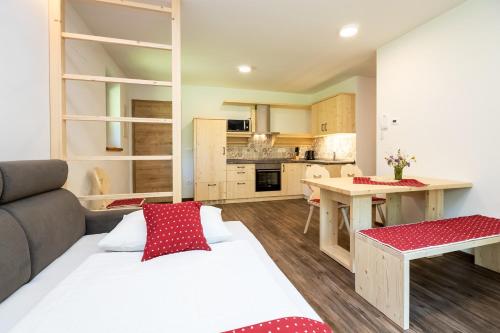 a living room with a bed and a kitchen at Bohinj Apartments Goldhorn Kingdom in Bohinj