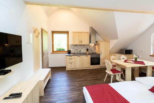 a room with two beds and a table and a kitchen at Bohinj Apartments Goldhorn Kingdom in Bohinj