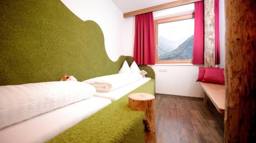 a room with two beds and a window at Almfamilyhotel Scherer in Obertilliach