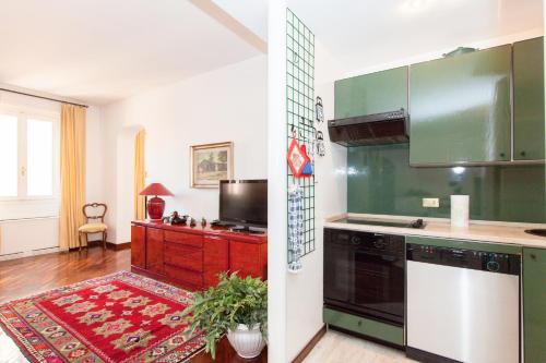 a kitchen with green and white appliances and a red rug at Dora Trevi Apartment in Rome