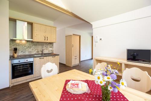 a kitchen with a wooden table with flowers on it at Bohinj Apartments Goldhorn Kingdom in Bohinj
