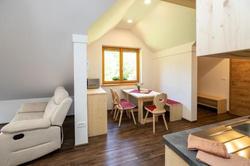 a kitchen and living room with a table and chairs at Bohinj Apartments Goldhorn Kingdom in Bohinj