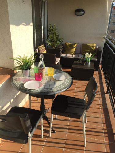 a patio with a table and chairs and a couch at The Hollidays Apartment in Calella