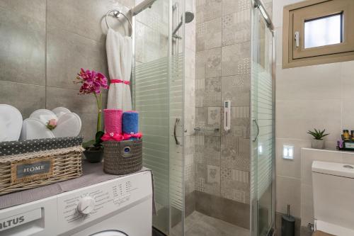 a bathroom with a shower and a washing machine at Floral Beach Apt with Lux Extras & Special Treats in Kolymvari