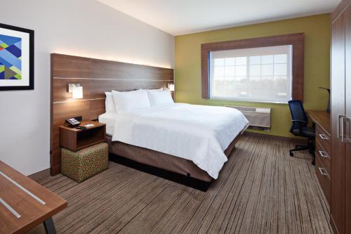 Cette chambre comprend un grand lit et un bureau. dans l'établissement Holiday Inn Express & Suites - Tulare, an IHG Hotel, à Tulare