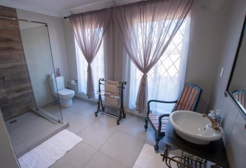 a bathroom with a sink and a toilet and a mirror at Pluvio in Parys