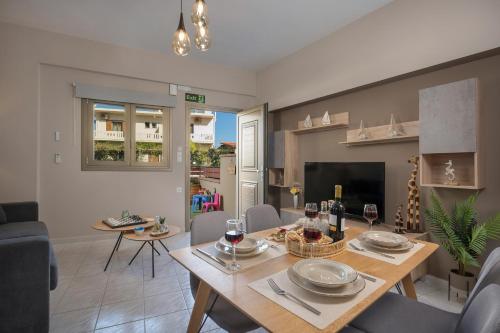 a dining room and living room with a table and chairs at Floral Beach Apt with Lux Extras & Special Treats in Kolymvari