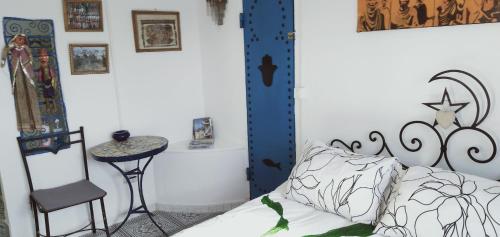 a bedroom with a bed and a chair and a table at Dar Warda in Bizerte