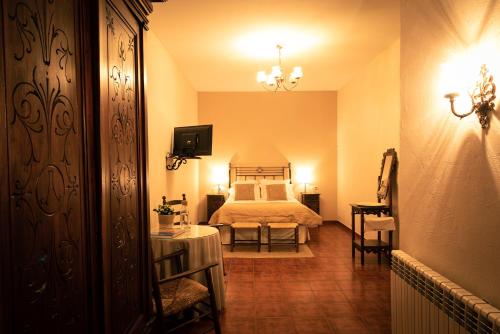 a bedroom with a bed and a television in it at Hospedium Hotel Val de Pinares in Bogarra