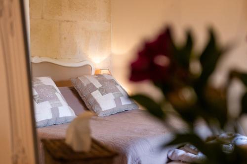 a bedroom with a bed with a mirror and a vase of flowers at Mas des Tourterelles in Saint-Rémy-de-Provence