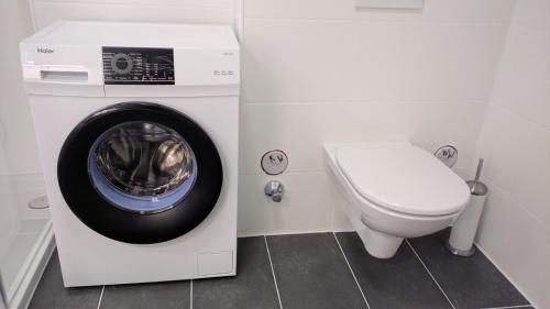 pralka w łazience obok toalety w obiekcie 204 Paris 59m2 4-8 Pers extr Bedroom w mieście Klagenfurt