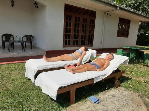 two women in bathing suits laying on beds at Anjana Villa in Hikkaduwa