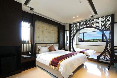 a bedroom with a large bed and a large window at Lo Hong ka Countryside House in Luodong