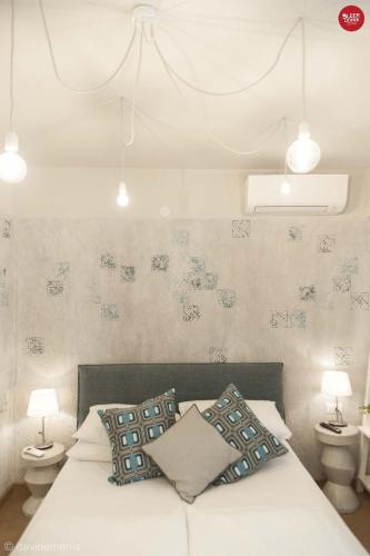 a bedroom with a bed with two night stands and two lamps at Sleep In Udine in Udine