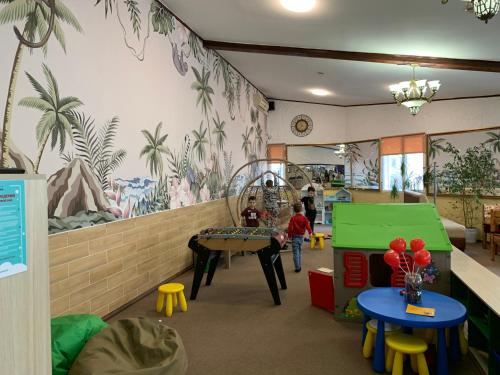 ein Kinderzimmer mit einem Wandbild von Palmen in der Unterkunft Galian Hotel in Odessa