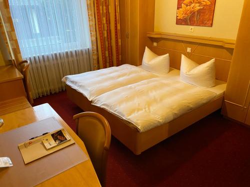 a hotel room with a bed and a table at Nürnberger Trichter Family-Business Hotel Garni in Nürnberg