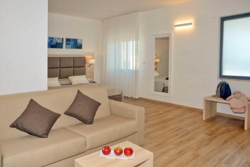 uma sala de estar com um sofá e um quarto em Hotel Albània em Otranto