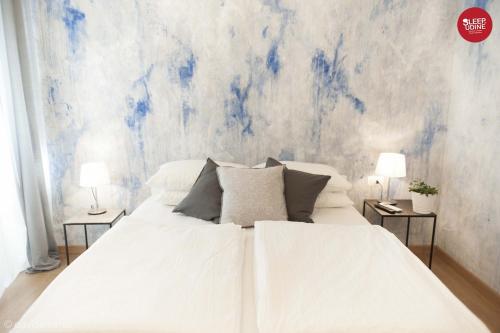 a bedroom with a white bed with two night stands at Sleep In Udine in Udine