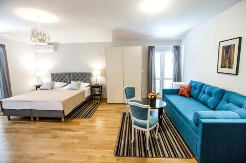 sala de estar con cama y sofá azul en Rooms Margarita, en Split