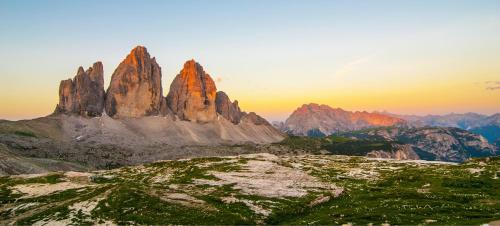 a mountain range with a sunset in the background at Hotel Schopfenhof in San Candido