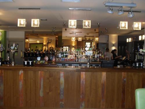 a bar with a wooden counter and a bartender at Hopping Hare in Northampton