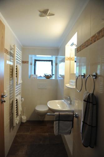 een witte badkamer met een wastafel en een toilet bij Gasthof Altes Forsthaus in Ramsau