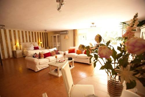 a living room with a couch and a table with flowers at Casa Vacacional Dhalia in Dos Hermanas