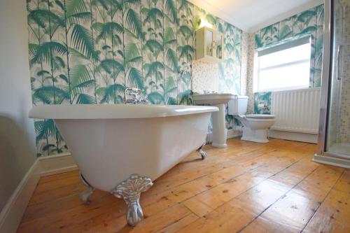 a bathroom with a large tub and a toilet at Broyle House, Chichester in Chichester