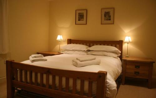a bedroom with a large bed with towels on it at Brewery Cottage, Chichester in Chichester