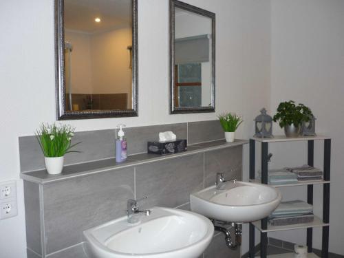 a bathroom with two sinks and a mirror at Ferienwohnung im Wiesengrund in Tarp