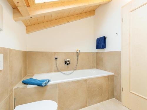 a bathroom with a bath tub in a room at Chiemgauferienwohnungen - Maier in Unterwössen