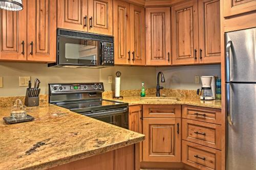 a kitchen with wooden cabinets and stainless steel appliances at Eagles Nest Crested Butte Townhome with Mtn Views in Crested Butte