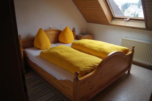a bedroom with two beds with yellow pillows and a window at Hotel Krone in Neresheim