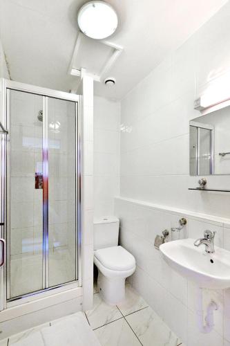 a white bathroom with a toilet and a sink at Hotel Oliver, 198 Cromwell Road SW50SN in London