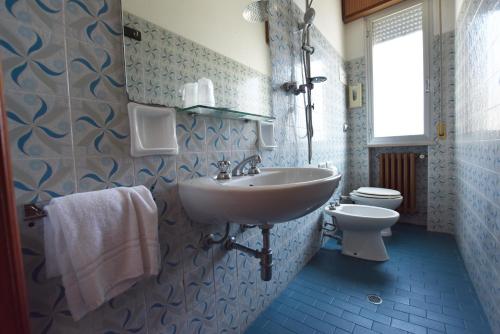 y baño con lavabo y aseo. en Hotel Azzurra, en Rímini