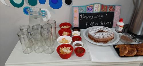 a table with a cake and other food on it at Hotel Mola in Puerto Iguazú