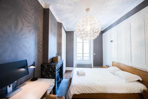 a bedroom with a large bed and a chandelier at Charmant appartement tout confort 134 Thiers - Lyon 6e in Lyon