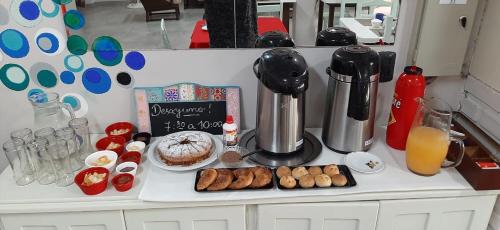 a counter with a mixer and a cake and some donuts at Hotel Mola in Puerto Iguazú