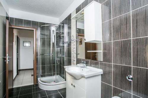 a bathroom with a sink and a shower and a toilet at Kaja - right next to the beach in Trogir