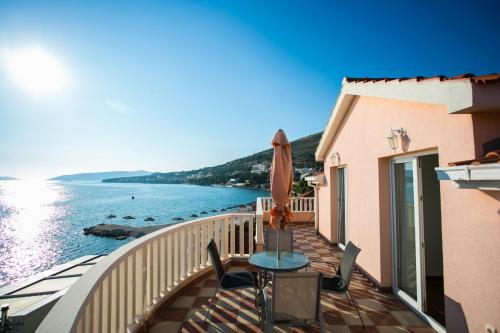 a balcony with a table and chairs and the ocean at Kaja - right next to the beach in Trogir