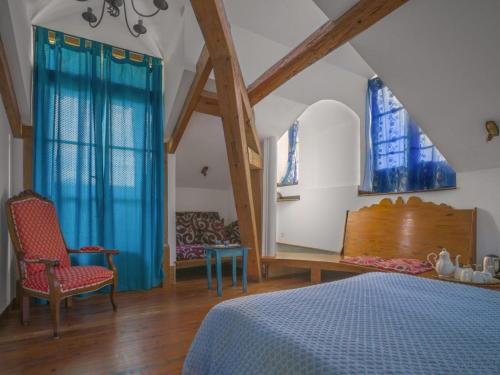 - une chambre avec un lit bleu et 2 fenêtres dans l'établissement Petit Château, à Laborde