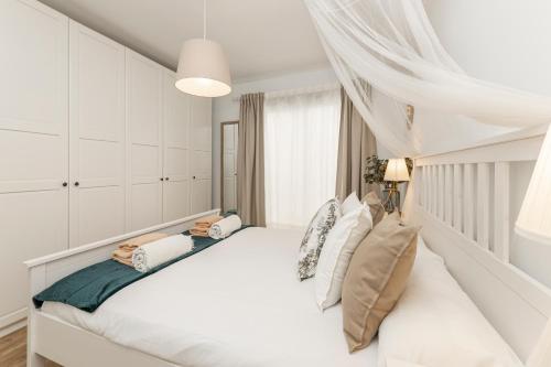 una camera bianca con un grande letto bianco con cuscini di Flower Beach Suite 20 a Playa Honda