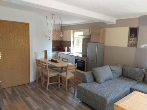 a living room with a couch and a table and a kitchen at Ferienappartment Henke in Hohnstein