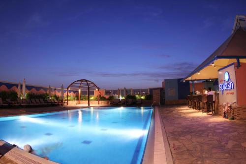 ein Pool auf dem Dach eines Gebäudes in der Nacht in der Unterkunft TIME Grand Plaza Hotel, Dubai Airport in Dubai