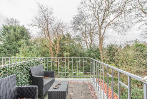 a balcony with chairs and a railing and trees at Boutique Appartement-Hotel Villa Juttershof in Bergen
